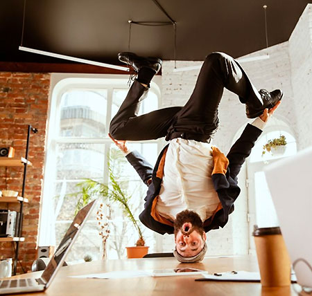 silly man upside down on desk beard black pants